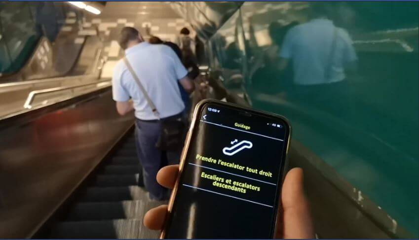 A person is using Evelity on the subway. They're on an escalator.