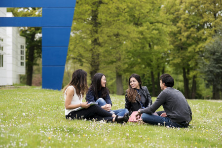 A group of students sitting on the grass at HEC Paris