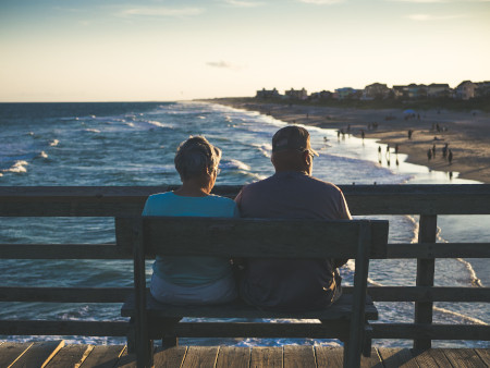 People with invisible disabilities sitting on a bench at the beach