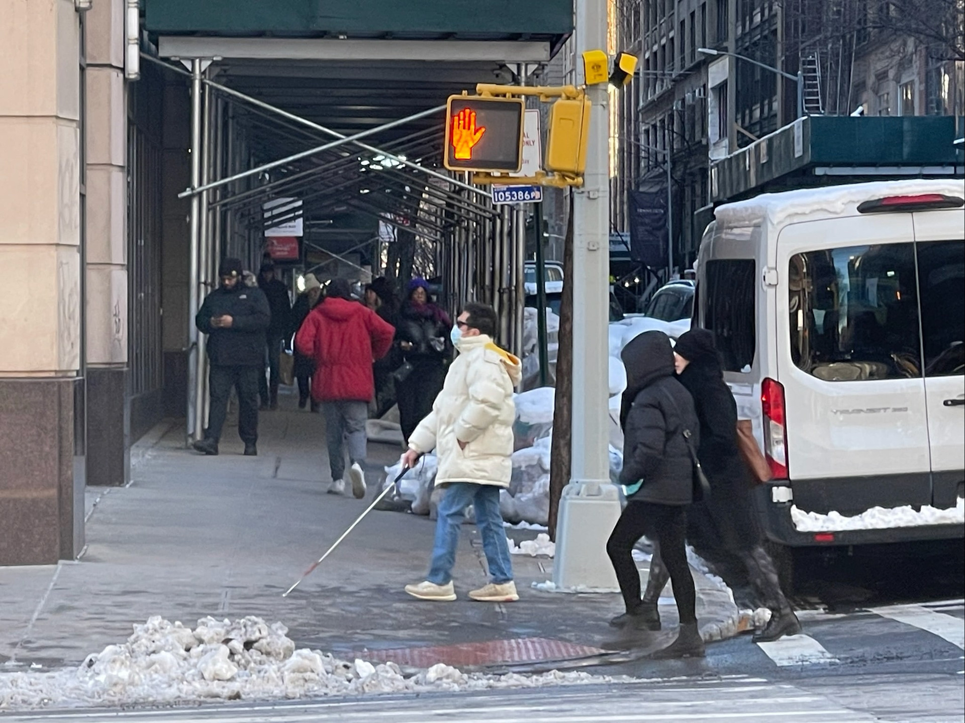 A pedestrian with a visual impairment crossing the street in New York