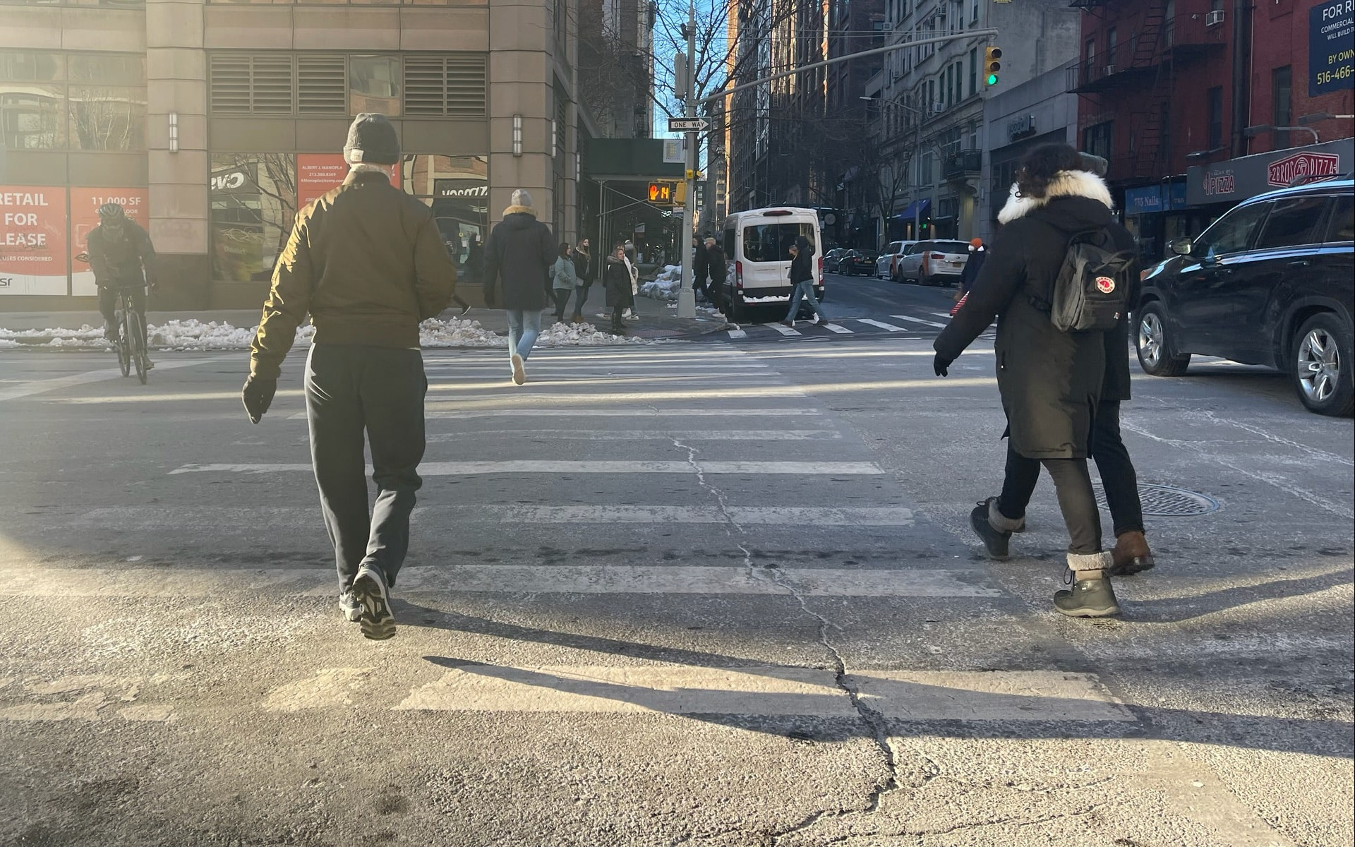 People crossing the street in New York City after pushing the button for the WALK signal