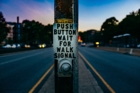 An audible pedestrian pushbutton with "push button, wait for WALK signal" written on it for blind and visually impaired pedestrians