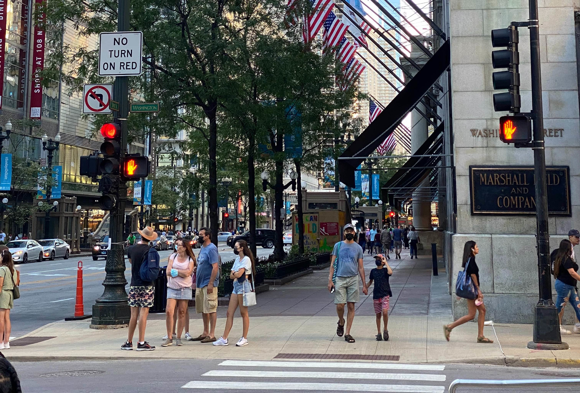 Several pedestrians waiting for the WALK signal at a crossing in Chicago