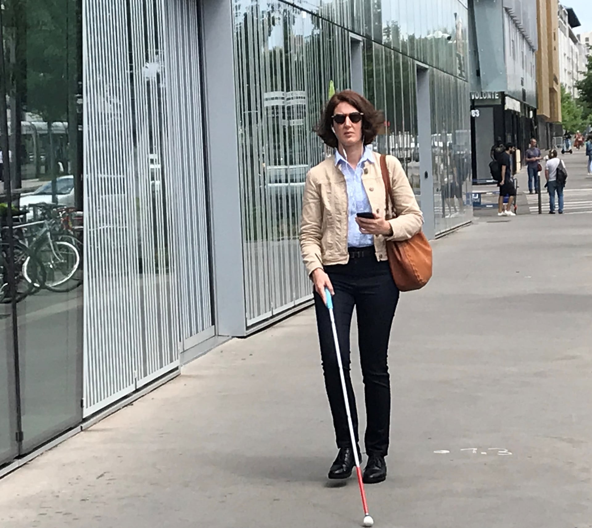 A blind woman uses Evelity, an assistive technology device, to find her bearings