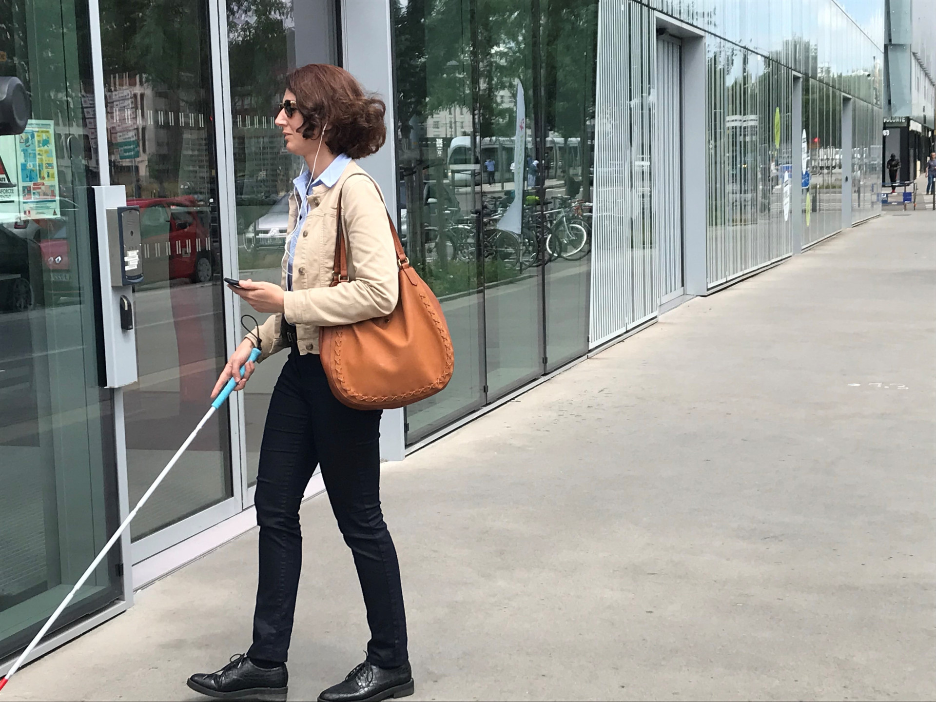 A blind woman is using Evelity as she's about to enter a smart building